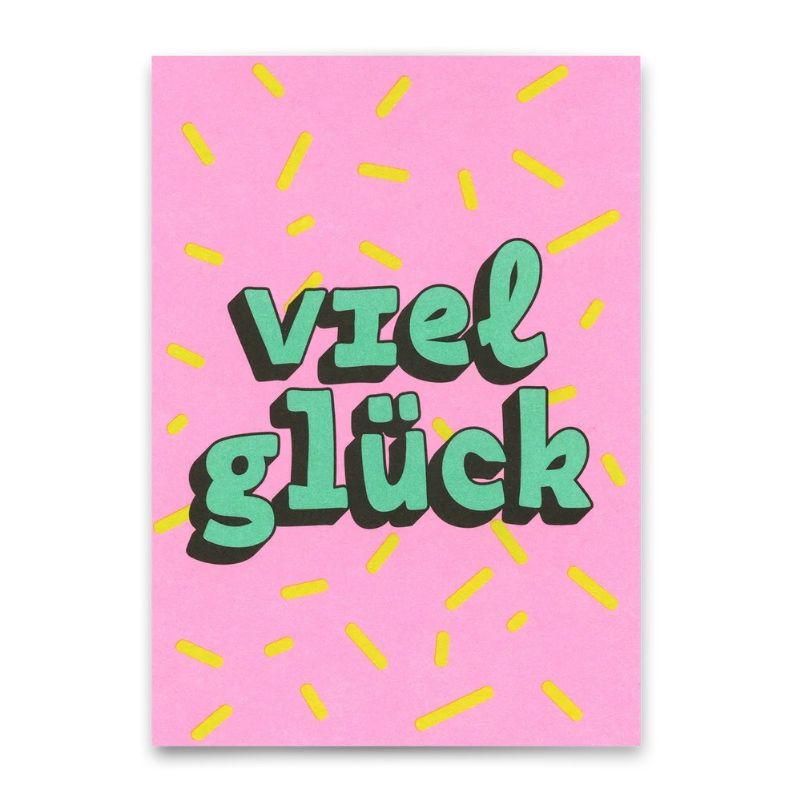 Postkarte mit mintgrünem Schriftzug "Viel Glück" und gelbem Konfetti auf pinkem Hintergrund